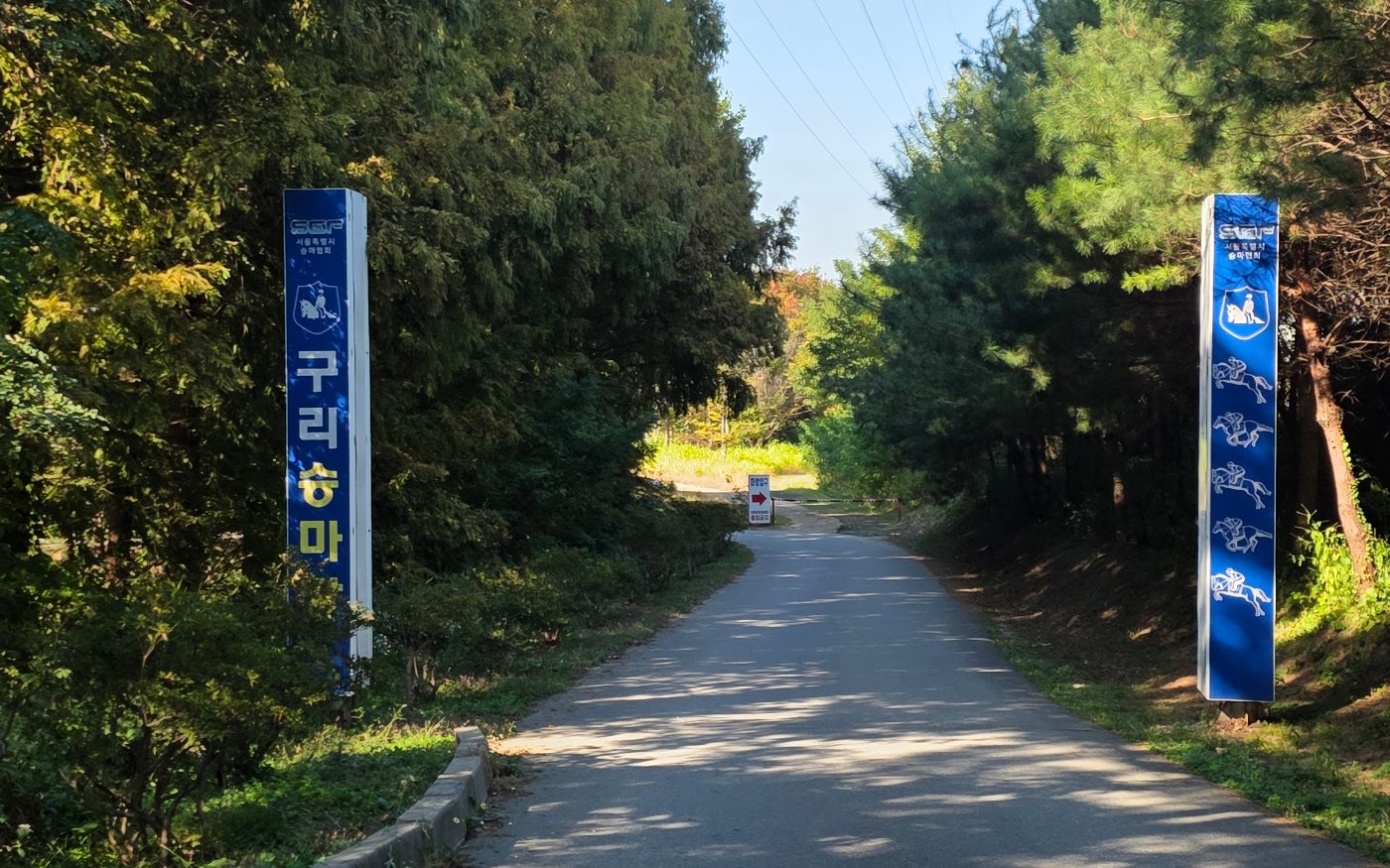 The entrance, with blue Seoul Equestrian Federation Guri Riding Grounds sign posts on both sides