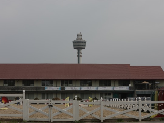 The red-roofed clubhouse with Guri Tower in view