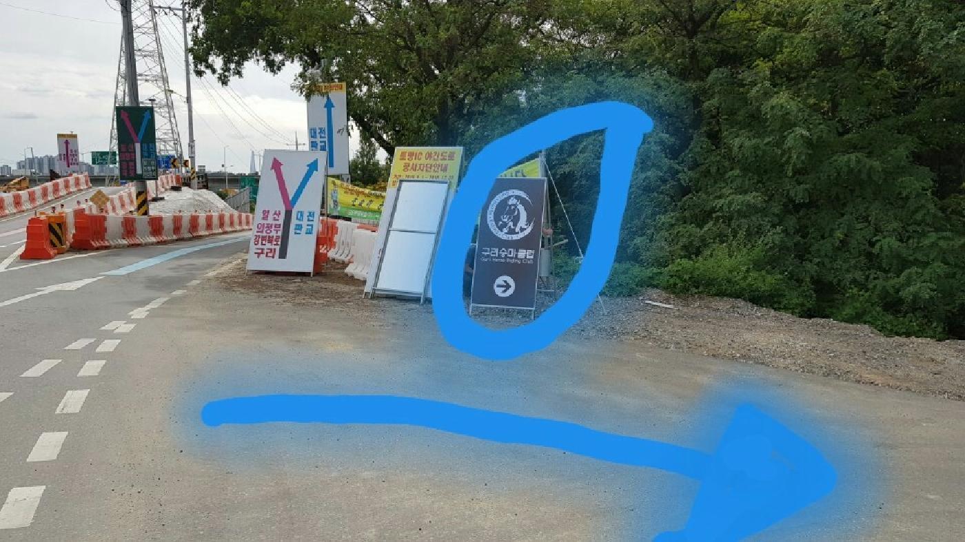 도로변 안내 표지판과 승마장으로 들어가는 길을 표시한 화살표